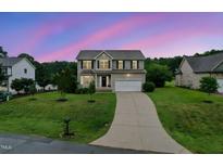 Charming two-story home featuring a well-manicured lawn and inviting curb appeal at twilight at 50 Consella Way, Franklinton, NC 27525