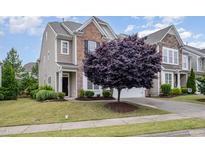 Charming two-story home with a combination of brick and siding, complemented by a beautifully landscaped front yard and a mature tree at 522 Finnbar Dr, Cary, NC 27519
