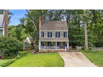 Charming two-story home featuring blue siding, white trim, black shutters and inviting front porch at 6717 Ebon Ct, Raleigh, NC 27615