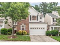 Charming two-story home featuring a brick facade, white siding, and an attached two-car garage at 8013 Morrell Ln, Durham, NC 27713