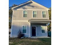 Charming two-story home featuring vertical siding, a covered porch, and neatly trimmed windows at 805 Da Vinci St, Durham, NC 27704