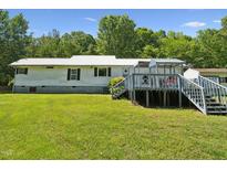 Charming single-story home with a spacious deck and a lush green lawn at 8089 Crawford Currin Rd, Oxford, NC 27565