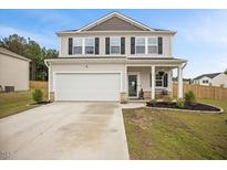 Charming two-story home with gray siding, black shutters, landscaped yard, and a two-car garage at 95 Buckthorn Dr, Youngsville, NC 27596