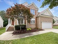 Charming brick home with a well-manicured lawn, mature landscaping, and attached two-car garage at 1005 Augustine Trl, Cary, NC 27518