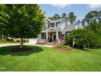 Charming two-story home featuring stone accents, a well-manicured lawn, and inviting curb appeal at 102 Bella Rose Drive, Chapel Hill, NC 27517