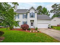 Charming two-story home with well-manicured lawn, beautiful landscaping, and attached two-car garage at 102 W Hill Dr, Cary, NC 27519