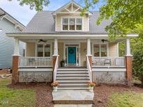 Charming two-story home featuring a welcoming front porch, a bright blue front door, and meticulous landscaping at 10579 Evergreen Spring Pl, Raleigh, NC 27614