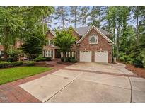 Charming brick home with a two-car garage, beautiful landscaping, and a brick walkway and driveway at 108 Vescova Ln, Morrisville, NC 27560