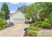 Charming home featuring a two-car garage, well-manicured lawn, and beautiful landscaping at 1113 Pilton Pl, Raleigh, NC 27604