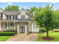 Charming home featuring stone accents, a metal roof, and lush landscaping at 112 River Dell Townes Ave, Clayton, NC 27527
