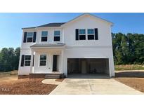A bright white two-story home featuring black shutters and a spacious two-car garage under a clear blue sky at 120 Cordoba Dr, Franklinton, NC 27525