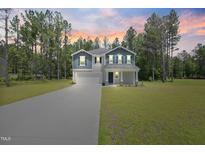 Charming two-story home with beautiful landscaping, long driveway and a welcoming front porch at 124 Teagarden Ct, Sanford, NC 27332