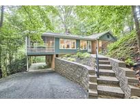 Charming home featuring beautiful landscape, steps leading to front door, a screened-in porch, and covered parking at 126 Weaver Rd, Chapel Hill, NC 27514