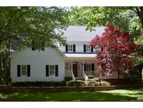 Charming two-story home with a white exterior, black shutters, and a well-manicured front yard at 1300 Keynes Ct, Raleigh, NC 27615