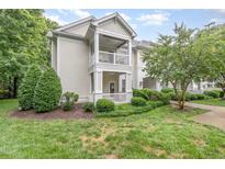 Inviting condo exterior showcasing a charming balcony, manicured landscaping, and lush greenery at 1310 Durlain Dr # 107, Raleigh, NC 27614