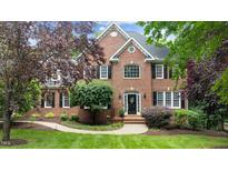 Stately brick home featuring a well-manicured lawn and mature landscaping at 1332 Kinsdale Dr, Raleigh, NC 27615