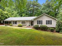 Charming one-story home features a well-manicured lawn and lush landscaping at 1706 Rangecrest Rd, Raleigh, NC 27612