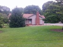 Charming single-story home featuring a brick chimney and a spacious front yard at 1942 Brier Ln, Graham, NC 27253