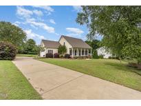 Charming one-story home with a inviting front porch, lush lawn, and long driveway at 20 Wood Ibis Way, Louisburg, NC 27549