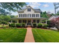 Charming home featuring a spacious front porch, manicured lawn and beautiful brick walkway at 200 Cobblepoint Way, Holly Springs, NC 27540