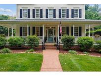 Charming two-story home with a welcoming front porch and lush landscaping at 200 Cobblepoint Way, Holly Springs, NC 27540