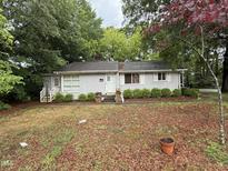 Charming single-story home with gray painted brick, trimmed hedges, and a welcoming front entrance at 200 Walnut St, Cary, NC 27511