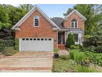 Charming red brick home boasts an attached two-car garage and beautiful landscaping at 2001 Dobson Ct, Raleigh, NC 27612