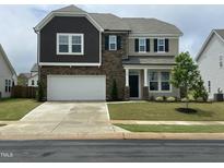 Beautiful two-story home with stone accents, a two-car garage, and manicured landscaping at 30 Junius Birch Trl, Franklinton, NC 27525