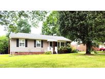 Charming single-story home with well-maintained lawn and mature trees, perfect for outdoor enjoyment at 404 Oakgrove Dr, Graham, NC 27253