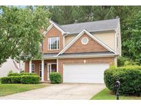 Charming two-story home with brick and siding, manicured lawn, and attached two-car garage at 404 Straywhite Ave, Apex, NC 27539