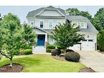 Charming two-story home featuring well-manicured landscaping, a blue front door and an attached two car garage at 4562 Brighton Ridge Dr, Apex, NC 27539