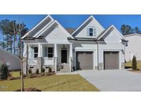 Charming two-story home featuring a two-car garage, stone accents, and a beautifully landscaped front yard at 461 Cedar Pond Ct, Knightdale, NC 27545