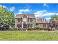 Charming brick two-story home with manicured lawn and mature trees in a quiet neighborhood at 4620 Gomar Ln, Fuquay Varina, NC 27526