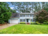 Charming two-story home with light blue siding, black shutters, and a well-maintained lawn at 5800 Heatherbrook Cir, Raleigh, NC 27612