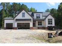 New construction showcasing the exterior elevation of a white home with an open garage at 5900 Tranquil Cv, Youngsville, NC 27596