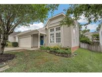 Charming home featuring a blue front door, attached garage, well-maintained lawn and beautiful front yard landscaping at 6 Newgate Ct, Durham, NC 27713