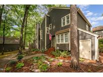 Charming two-story home with landscaped yard and gray siding, nestled in a wooded area at 6035 Sentinel Dr, Raleigh, NC 27609