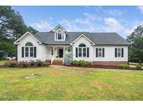 Charming home with a well-manicured lawn, beautiful landscaping, and classic architectural details at 6737 Vernie Dr, Raleigh, NC 27603