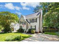 Charming two-story home featuring a well-manicured lawn, neutral siding and black shutters under a sunny sky at 6912 Baywood Dr, Raleigh, NC 27613