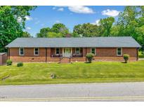 Charming brick home with a well-manicured lawn and inviting front porch at 750 Greenleaf Rd, Angier, NC 27501