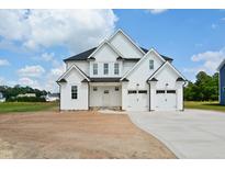 New two-story home featuring white siding, a black roof, attached garage, and a neatly paved driveway at 7719 Barefoot Rd, Fuquay Varina, NC 27526