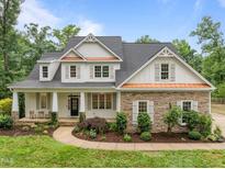 Charming two-story home with a welcoming front porch, stone accents, and beautifully landscaped yard at 109 Henrys Ridge Rd, Pittsboro, NC 27312
