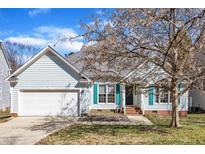 Charming one-story home with light blue siding, white garage door, well-kept lawn and blue shutters at 11113 N Radner Way, Raleigh, NC 27613