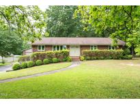 Charming brick home with well-maintained landscaping and a curved walkway to the front door at 1822 Routh Rd, Burlington, NC 27217