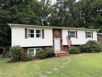 Charming home with a brick facade, complemented by an American flag and well-maintained landscaping at 210 Crest Rd, Henderson, NC 27536