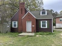 Charming two-story home featuring a brick chimney, dormer window and classic green window shutters at 2507 Chapel Hill Rd, Durham, NC 27707