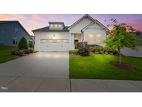 Beautiful white home featuring an attached garage and well-manicured landscaping at 2537 Cedar Hedge Ct, Apex, NC 27523