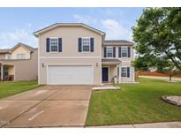 Charming two-story home with a well-manicured lawn, attached two-car garage and blue shutters at 2604 Fortrose Ln, Fuquay Varina, NC 27526