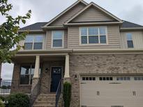 Beautiful two-story brick and shingle home with inviting front porch and well-manicured landscaping at 319 Brinkley Cir, Mebane, NC 27302