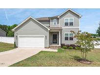 Charming two-story home with a two-car garage, manicured lawn, and inviting front entrance at 328 Avery Meadows Dr, Smithfield, NC 27577